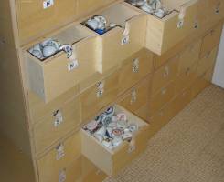 Pharmacist's cabinet with manny small drawers for storage of unsorted ceramic caps