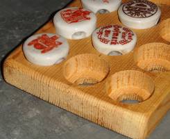 Wooden board with holes of the size of ceramic caps drilled into it