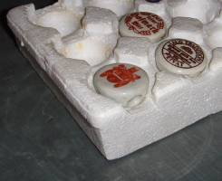 Foamed polystyrene insert used for packaging of kentchup tubes, now used for storage of ceramic caps