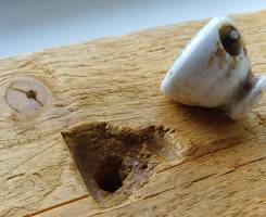 timber with carved out shape of a ceramic bottle cap