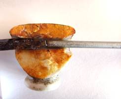 Pushing out of rusty wire, seen in cross sections of a cermic cap (II)